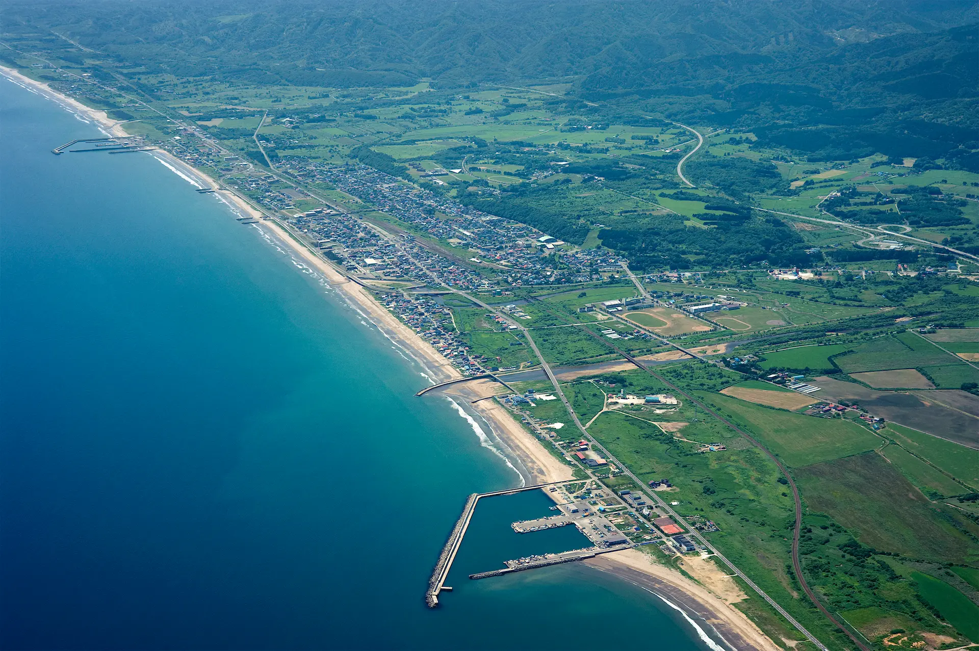 市街地の空撮。 海・山の大自然に囲まれたまちです。